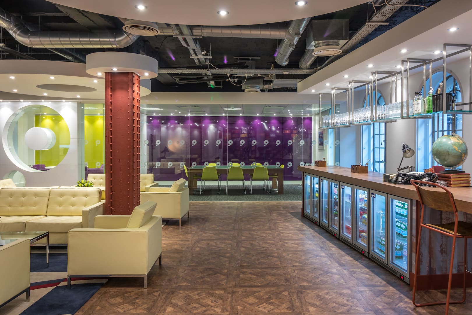 Breakout area with yellow sofas and bookshelves at Paragon Insurance, London